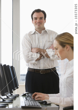 Businessman with arms crossed behind businesswoman 10373305
