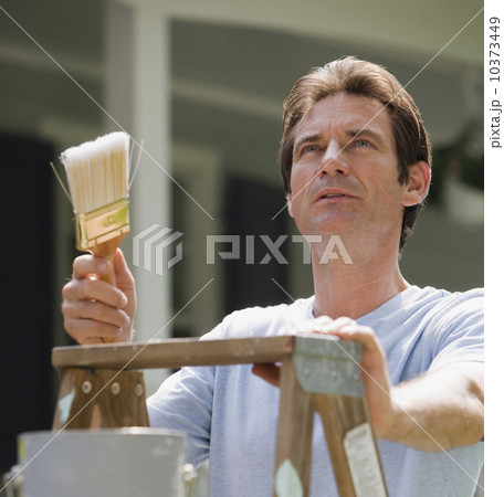 Man on ladder with paintbrush 10373449