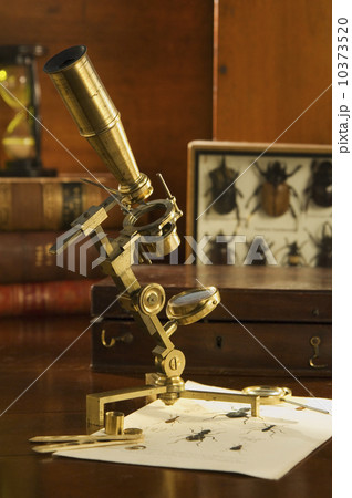 Old fashioned microscope on table 10373520