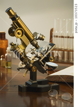Old fashioned microscope on table 10373523