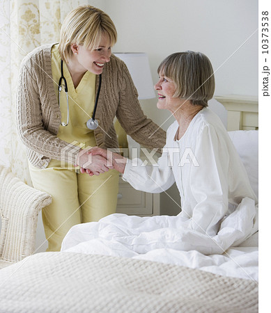 Nurse helping senior woman out of bed Nurse helping senior woman out of bed 10373538