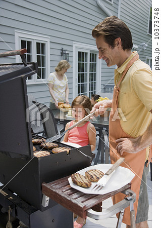 Family barbequing on deck 10373748