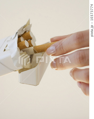 Woman talking cigarette out of pack 10373774