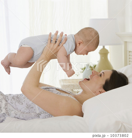 Mother playing with baby on bed Mother playing with baby on bed 10373802