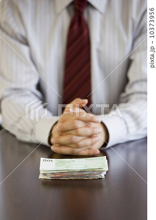 Businessman with stack of Euro banknotes Businessman with stack of Euro banknotes 10373956