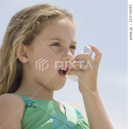 Girl using asthma inhaler Girl using asthma inhaler 10374093