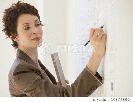Businesswoman writing on wall chart 10374399