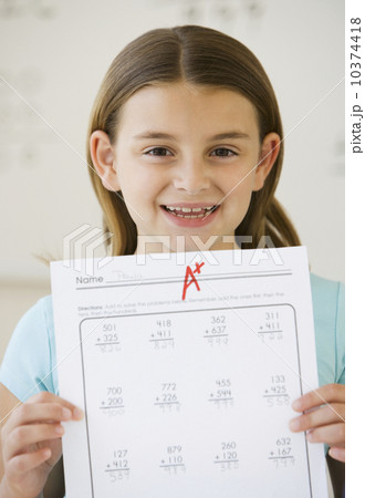 Girl holding schoolwork with A plus grade  10374418