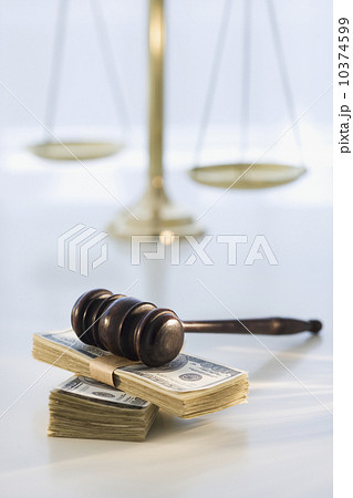 Gavel on stack of money with scales in background Gavel on stack of money with scales in background 10374599