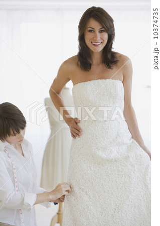 Bride having dress fitted 10374735