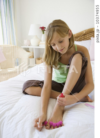 Teenaged girl painting toenails 10374955