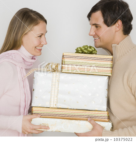 Couple holding pile of gifts Couple holding pile of gifts 10375022