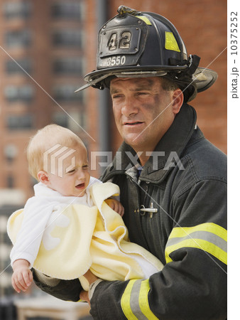 Male firefighter carrying baby Male firefighter carrying baby 10375252