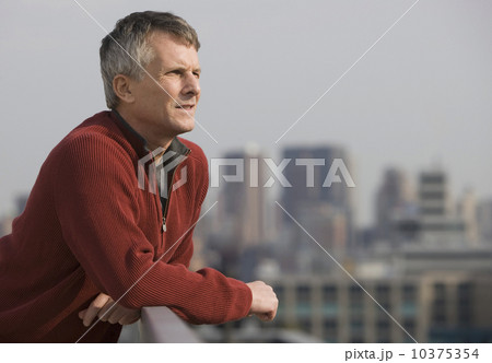 Man leaning on balcony railing Man leaning on balcony railing 10375354