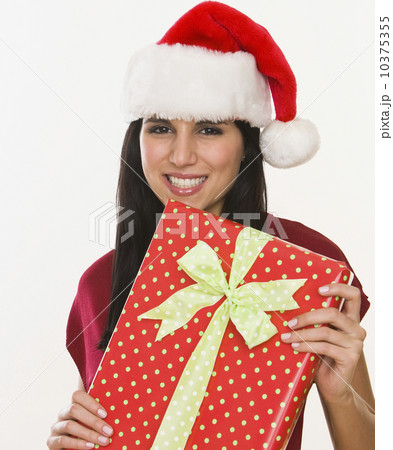 Woman in Santa Claus hat holding gift Woman in Santa Claus hat holding gift 10375355