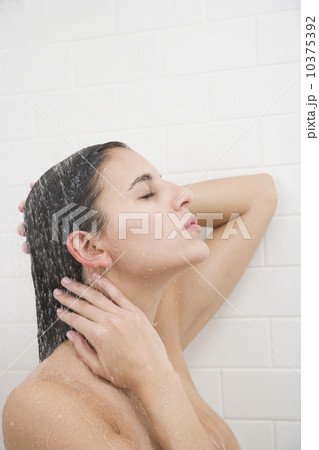 Woman standing under shower Woman standing under shower 10375392