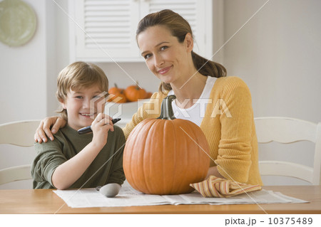 Mother and son decorating pumpkin 10375489