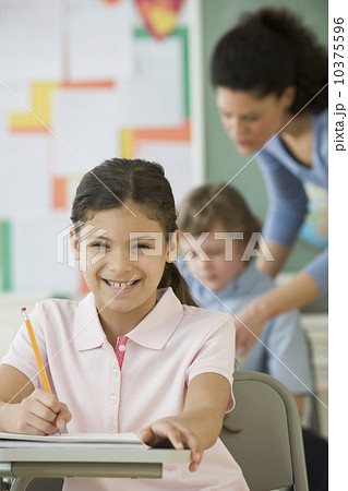 Hispanic girl writing at school desk Hispanic girl writing at school desk 10375596