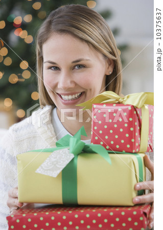 Woman holding pile of Christmas gifts 10375637