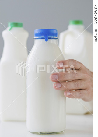 Man reaching for milk bottle 10375687