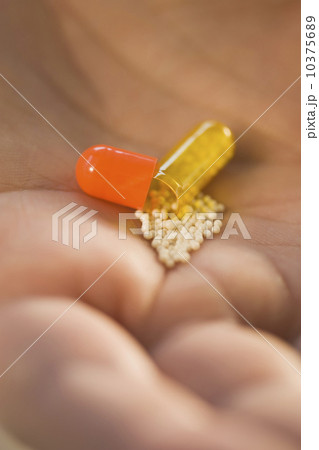 Close up of open medication capsule in man’s hand 10375689