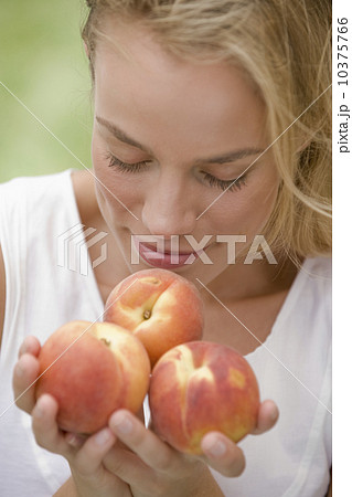 Woman smelling fresh peaches 10375766