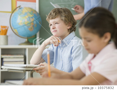 Boy thinking at school desk Boy thinking at school desk 10375832