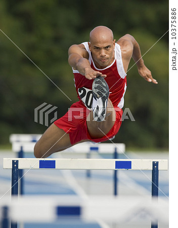 Runner jumping over hurdle 10375886
