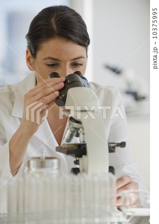 Scientist using microscope in pharmaceutical laboratory 10375995