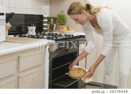 Woman removing pie from oven Woman removing pie from oven 10376049