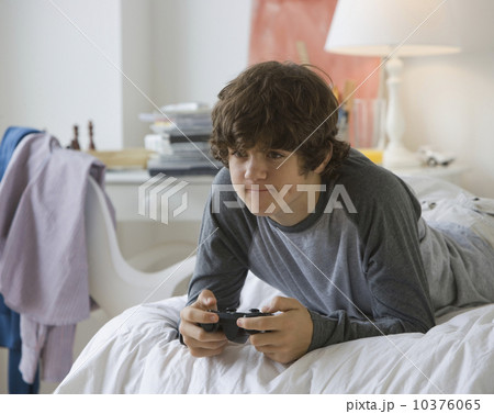 Teenaged boy playing video games Teenaged boy playing video games 10376065
