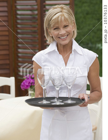 Waitress holding tray of wine glasses Waitress holding tray of wine glasses 10376133