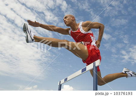 Runner jumping over hurdle 10376193