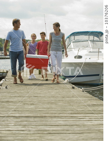 Family walking on boat dock with cooler 10376206