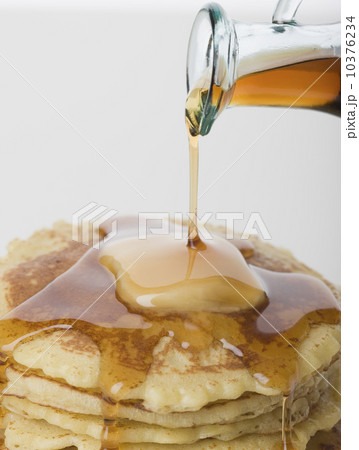 Close up of maple syrup being poured on pancakes 10376234