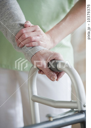 Nurse helping senior woman in walker 10376376