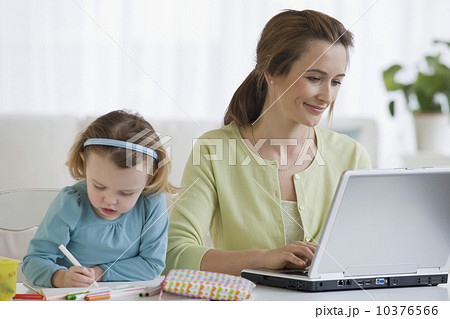 Mother working next to daughter coloring Mother working next to daughter coloring 10376566