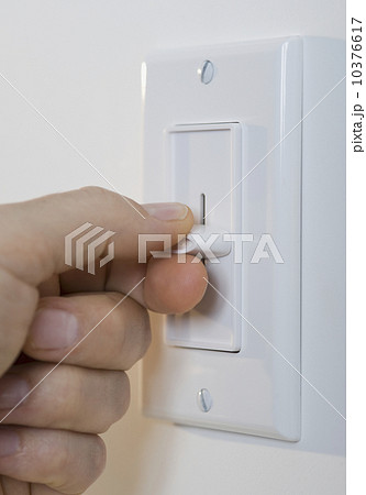 Man adjusting light dimmer 10376617
