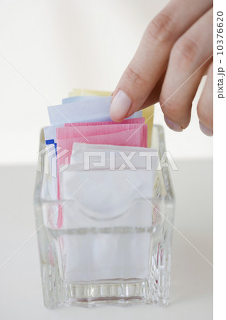 Woman reaching for sweetener packet Woman reaching for sweetener packet 10376620