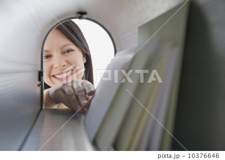 Woman reaching into mailbox for mail 10376646