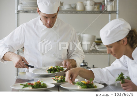 Male and female chefs plating food 10376679