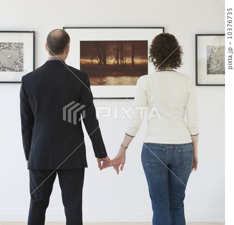 Couple looking at art in art gallery 10376735