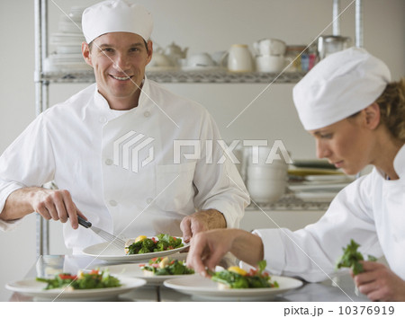 Male and female chefs plating food Male and female chefs plating food 10376919