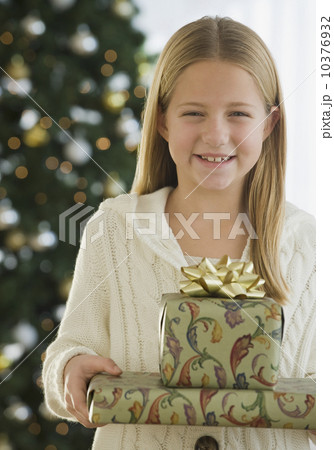 Girl holding stack of Christmas gifts 10376932