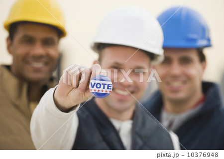 Multi-ethnic construction workers with Vote button 10376948