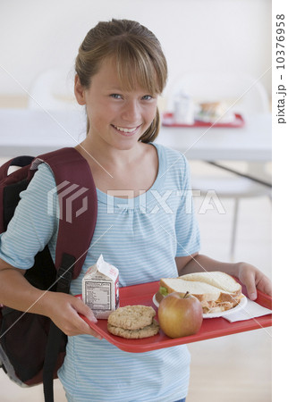 Girl carrying lunch tray in school cafeteria Girl carrying lunch tray in school cafeteria 10376958