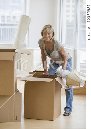 Woman unpacking moving boxes Woman unpacking moving boxes 10376987