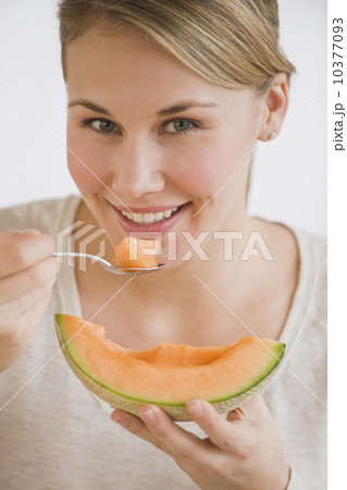 Woman eating melon wedge 10377093