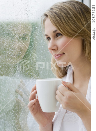 Woman looking out rainy window Woman looking out rainy window 10377185
