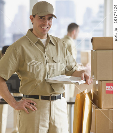 Delivery man standing next to packages Delivery man standing next to packages 10377224